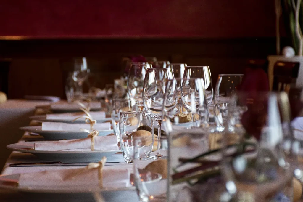 A table set for a dinner party with empty wine glasses and plates.