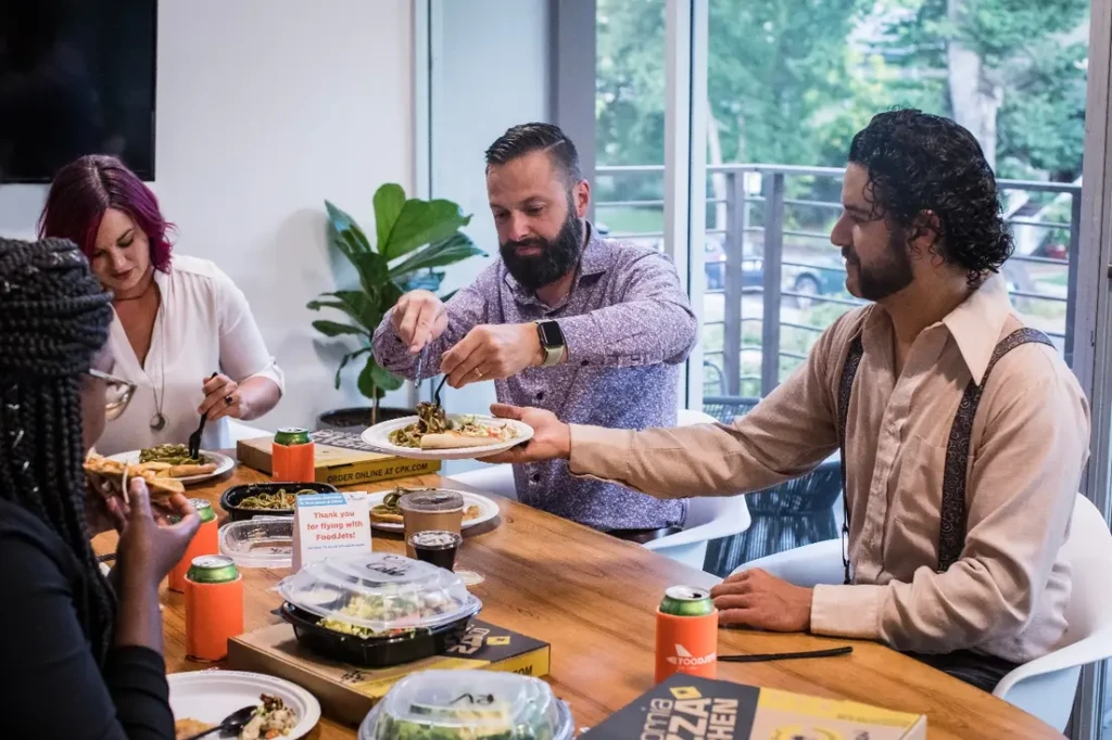 Team members having pizza at restaurant.