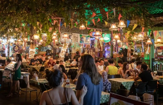 People enjoying food and drinks at a city restaurant.