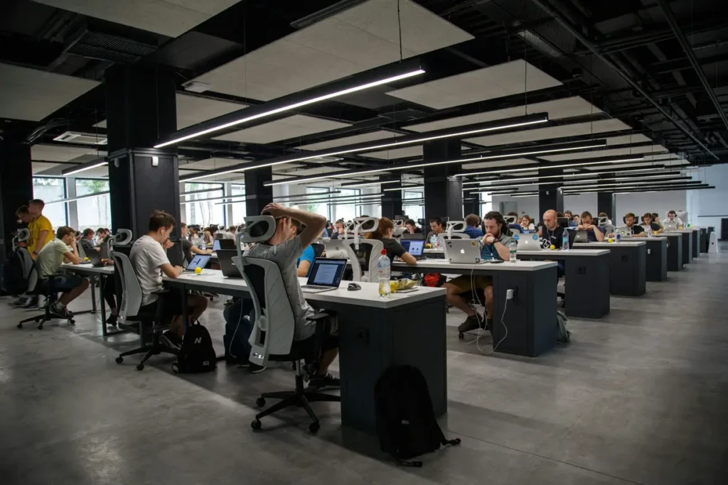 An open office with individuals working on computers, creating a productive and collaborative atmosphere.