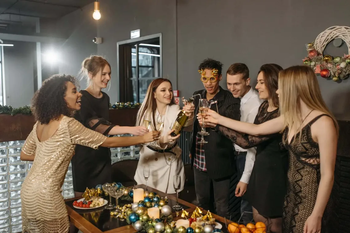 A festive Christmas party with a group of people raising their champagne glasses in celebration.