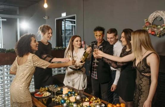 A festive Christmas party with a group of people raising their champagne glasses in celebration.