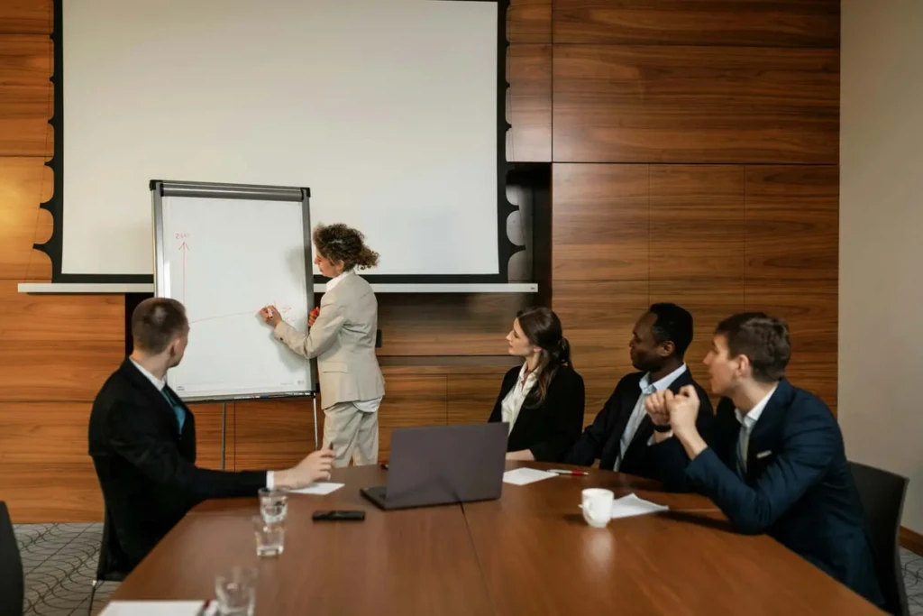 Businesswoman delivering a presentation to team members in a meeting room.