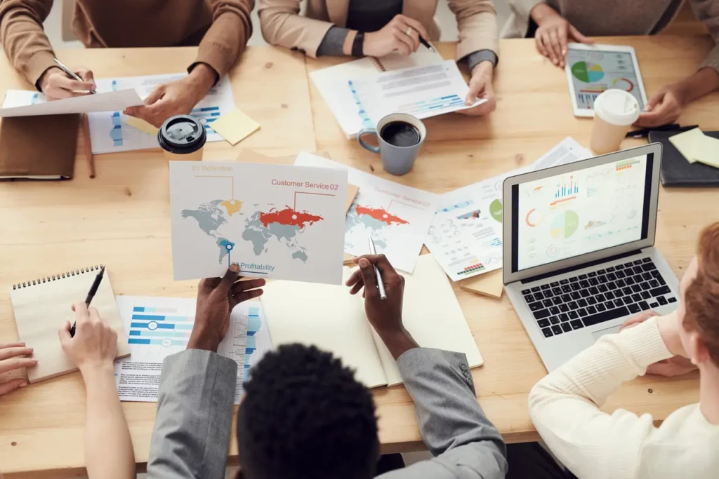 Business people discussing strategy with a map and documents on a table.