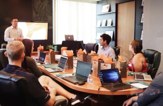 A team of professionals sitting together at a table with laptops, working on a shared task or project.