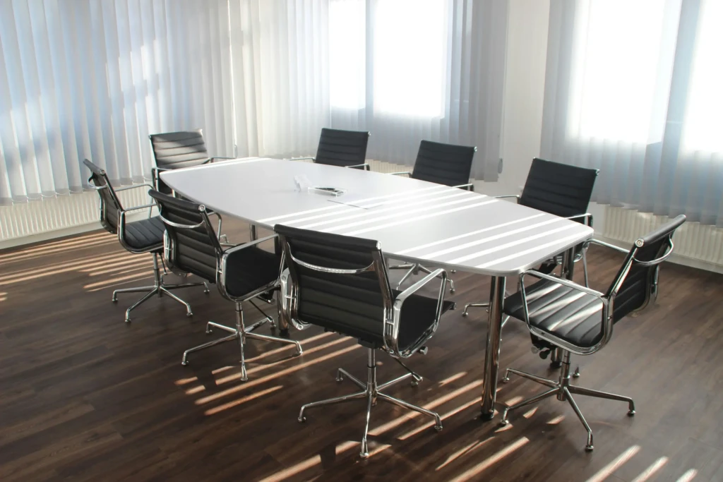 A conference table surrounded by chairs in a meeting room.