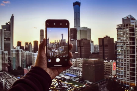 A person capturing cityscape with smartphone.