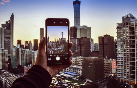 A person capturing cityscape with smartphone.